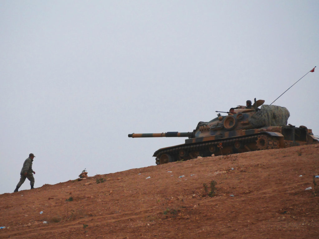 A Turkish soldier approaches a tank on the Syrian border doing not much at all besides a calibrated defensive posture. ©2014 Derek henry Flood