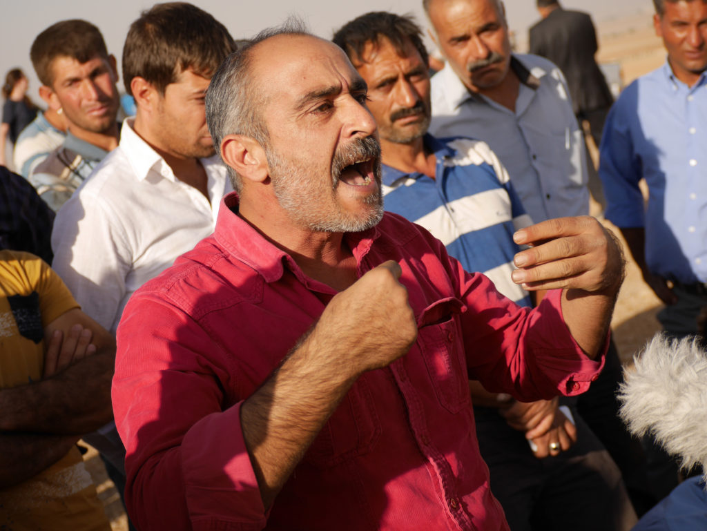 A Kurdish man fed up with Turkish policy vis-a-vis Kobane vents his anger at a television camera. ©2014 Derek Henry Flood